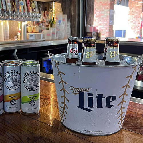 Beer bottles in bucket and beer cans on a bar